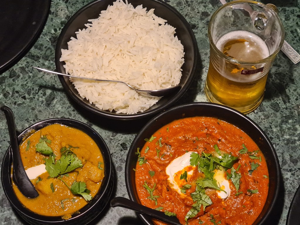 Tip view of rice, beer, butter chicken and another curry I forget (but yummy!)