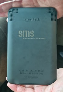 Back of the damaged kindle with SMS engraved on it